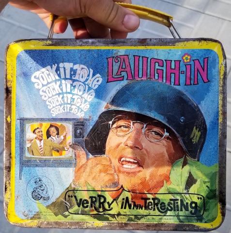 POST-WAR AMERICAN TV-SHOW LAUGH-IN - SOCK-IT-TO-ME LUNCH BOX SHOWING THE ACTOR WITH A GERMAN HEER WEHRMACHT HELMET WITH A NICE DECAL WITH SWASTIKA