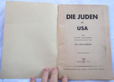 WITH 100+ PHOTOS PRESENTING JEWRY IN THE UNITED STATES IN THE MOST UNPLEASANT WAY!  This very hard to find anti-semitic 7 x 9-3/4 inch, 64-pages soft cover book by Dr. Hans Diebow was published 1939 by Central Publishing House of the NSDAP in Berlin. The copy offered for sale was published 1941. The book contains more than 100 photos on Jewry in the United States of America, of course mostly criminals, politicians or dirty ghetto Jews! The cover shows some signs of wear and there are two small pieces missin