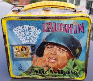 POST-WAR AMERICAN TV-SHOW LAUGH-IN - SOCK-IT-TO-ME LUNCH BOX SHOWING THE ACTOR WITH A GERMAN HEER WEHRMACHT HELMET WITH A NICE DECAL WITH SWASTIKA